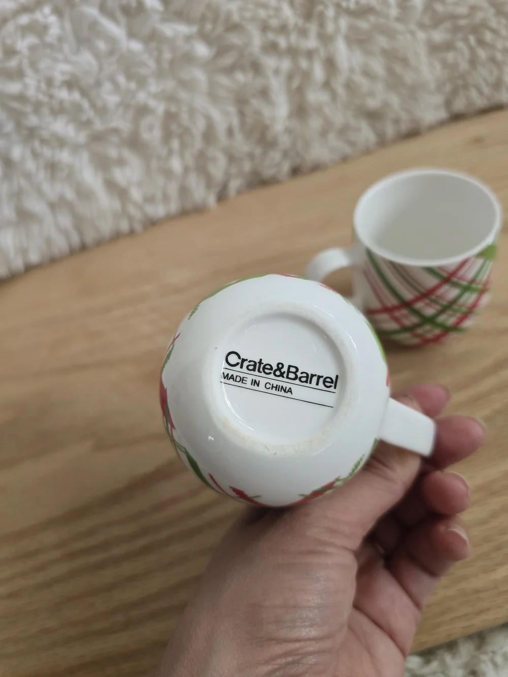 Crate & Barrel brand holiday mugs featuring a red and green plaid pattern